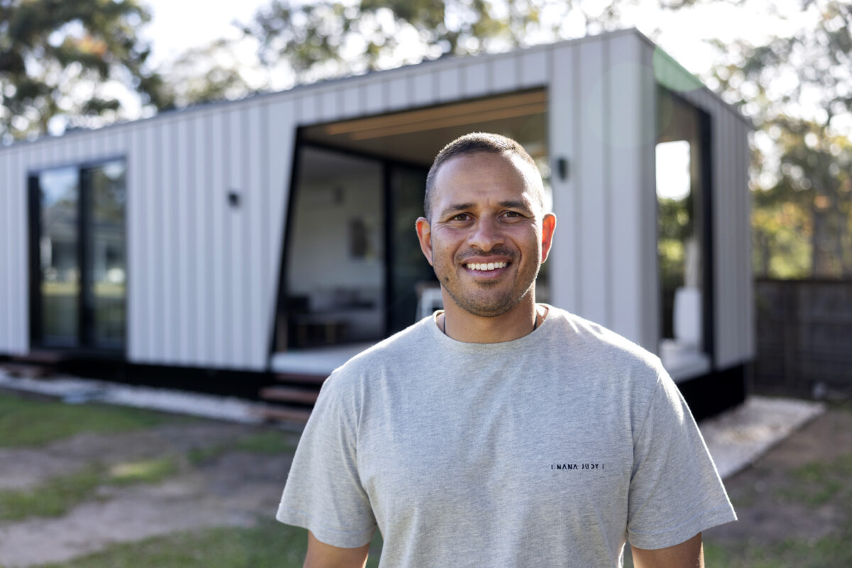 ModnPods Ambassador Usman Khawaja standing in front of a ModnPod building.